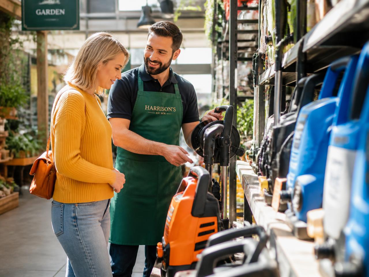Staff member helping a customer in a bright hardware and garden store