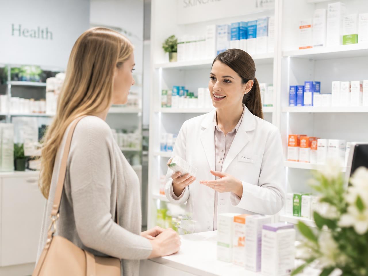 Pharmacist advising a customer in a bright pharmacy